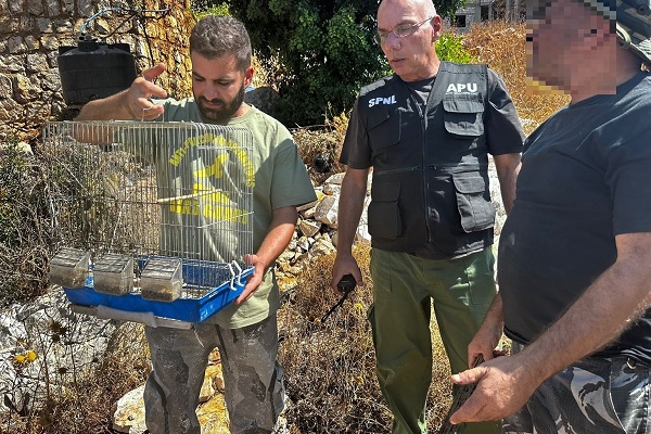 Mitarbeiter von Komitee und MESHC stellen frisch gefangen Vögel bei einem Wilderer (rechts) sicher